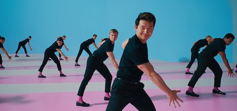 Ken (Simu Liu) is surrounded by 9 other Kens in a choreographed dance scene.