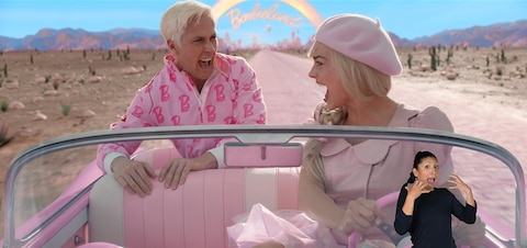 Barbie (Margot Robbie) and Ken (Ryan Gosling) scream at each other in surprise as they drive in her pink convertible out of Barbieland. In the bottom right corner, ASL performer Leila Hanaumi signs "Ahhh!”