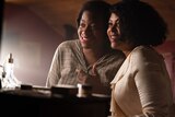 Celie and Shug smile at themselves in the mirror.