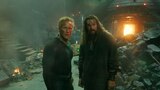 Orm and Aquaman stand amid rubble in an industrial space.