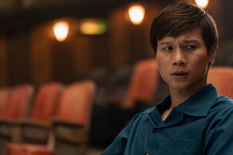 The Captain looks to his left with concern while seated in a theater.