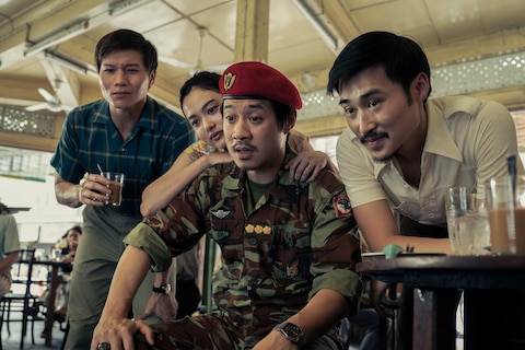 The Captain, a young woman, Bon, and Man all look at something out of frame with mixed emotions.