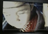 ASL performer Otis Jones signs “survival” in front of a scene from the movie that shows a blurry close-up image of Jia on surveillance video.