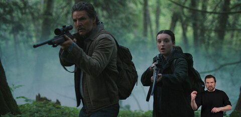 Joel and Ellie stand in a densely wooded area with their rifles raised. They look at something out of frame with shocked expressions. ASL interpreter Daniel Durant signs “snarling sounds.” 