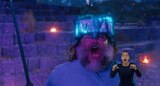 Steve wears a glowing, blue diamond helmet and holds a sword as he looks up at something out of frame and screams in fear. ASL interpreter Sophia Morales signs “nooo!”