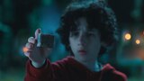 Henry reaches out to gently hold a small, floating cube.