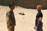 Avanti and Col. Lockjaw stand facing each other in a desert landscape. ASL interpreter Otis Jones signs “come.”