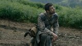 Criston Cole kneels on a dirt path in a green countryside; his clothes, boots, and face streaked with mud. He looks up at something out of frame while resting on one knee.