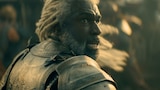 Close-up of Corlys Velaryon. He wears armor and looks apprehensively at something out of frame.