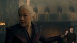 Rhaenyra Targaryen stands in a candlelit stone room and looks at something out of frame with her eyebrows raised. In the bottom right side of the image, ASL dubber Landen Gonzales signs the letter “A”.